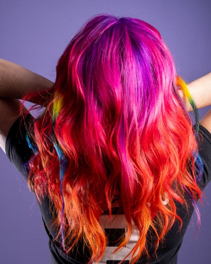 Lang golvend haar van roze en paars naar rood en oranje