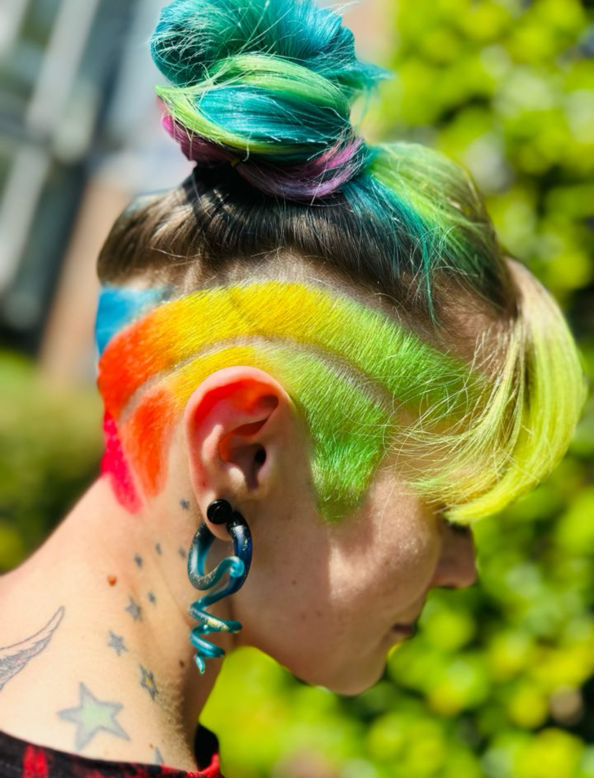 Knot in groen en blauw met een opgeschoren zijkant in regenboogkleuren, van opzij